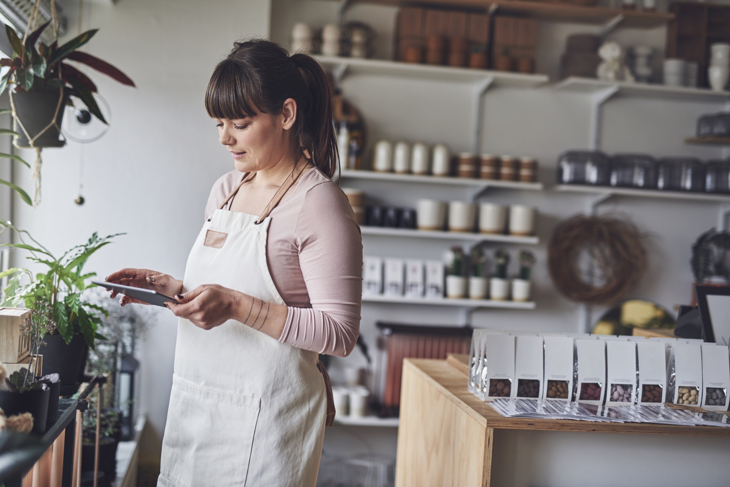 Blomsterhandler bruger en tablet i sin butik