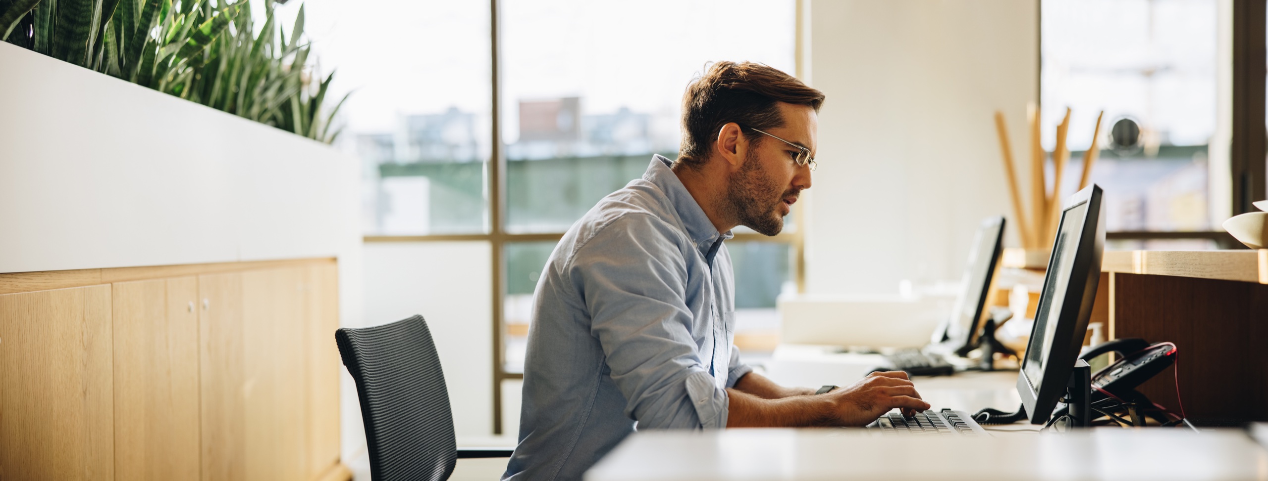 Mand arbejder ved en computer på kontoret